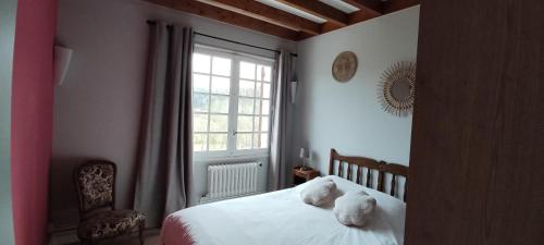 two stuffed animals sitting on a bed in a bedroom at Balcon des fées in Le Malzieu-Ville