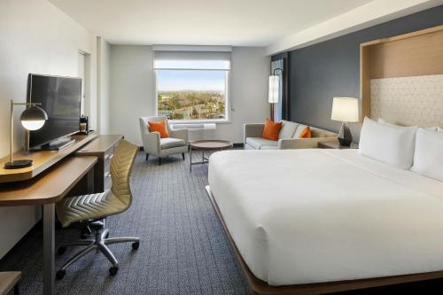a hotel room with a large bed and a desk at Courtyard by Marriott across Universal Orlando in Orlando