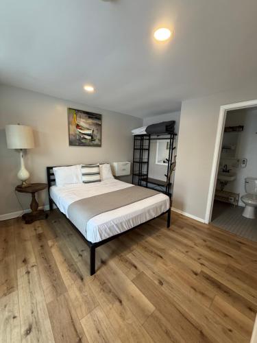 a bedroom with a bed and wooden floors at Great Lakes Resort - Family Suite - Suite 1 in Lexington