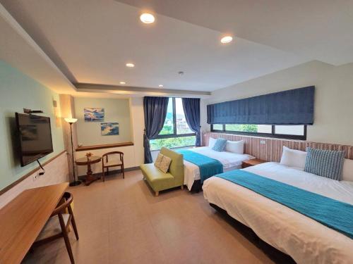 a hotel room with two beds and a television at Bestime B&B in Jiji