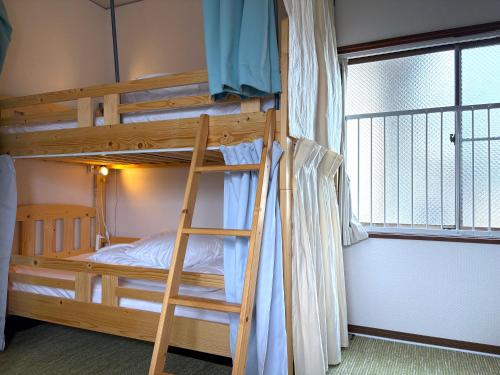 a bunk bed with a ladder in a room at Hook House Stay Kanazawa in Kanazawa