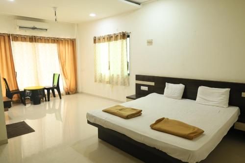 a bedroom with a bed with two towels on it at Blue Diamond Dapoli in Murūd