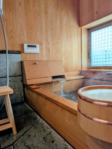 a bath room with a tub and a sink at 和の貸切宿yanagiya in Daisen