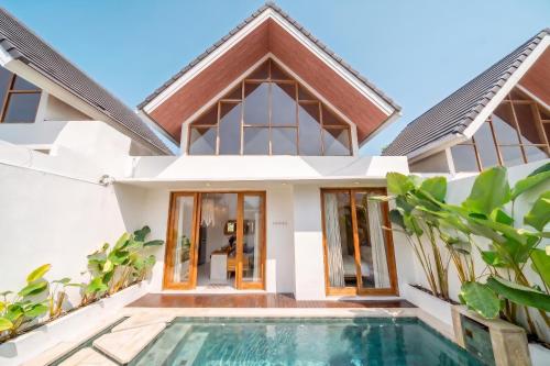 a villa with a swimming pool in front of a house at Sunset Heaven - Private Pool Cozy Villa with Patio in Kerobokan