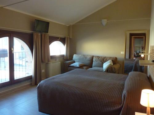 ein Schlafzimmer mit einem Bett und einem Sofa in der Unterkunft Agriturismo Boschi Celati in Roncaglia