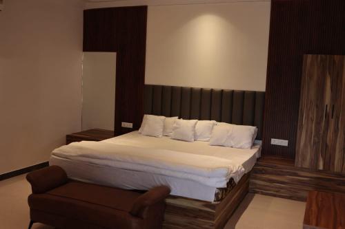 a bedroom with a large bed and a chair at Anantiva Farms in Rāma