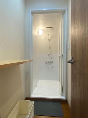 a bathroom with a shower with a glass door at Guest House KURA 776 Mt Fuji View and 1 min to Gekkoji Station in Fujiyoshida