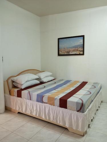 a bedroom with a bed with a picture on the wall at Verde Royale Resort in Calasiao