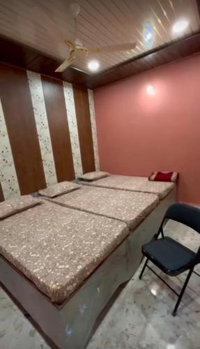 a bed and a chair in a room at Shree ram lodge in Maihar