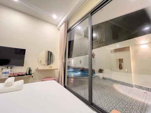 a bedroom with a bed and a bathroom with a shower at Cham Charm Home Mui Ne in Ấp Thiện Phước