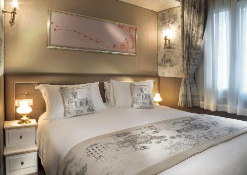 a bedroom with a large white bed with pillows at Papadopoli Hotel Venezia - MGallery Collection in Venice