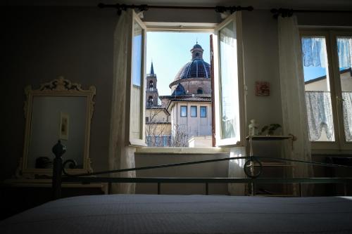 a bedroom with a view of a building from a window at La Pausetta in Foligno