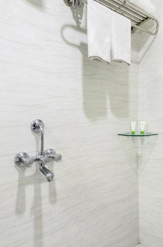 a bathroom with a sink and a faucet at Hotel Raya Inn in Jaipur