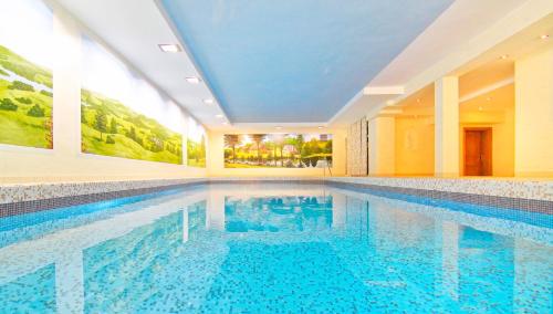 a swimming pool with blue water in a building at Landhaus Wacker in Wenden