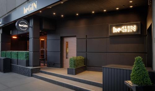 a restaurant with a sign on the side of a building at Glasgow Grosvenor Hotel in Glasgow