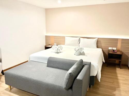 a bedroom with a bed with two teddy bears on it at Le Srivaree Suvarnabhumi Airport Hotel in Samutprakarn
