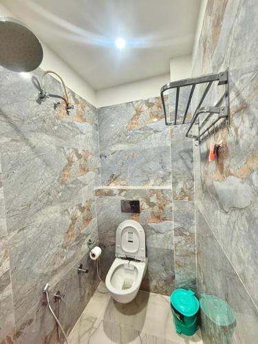 a bathroom with a toilet and a shower at The Kridha Palace in Ayodhya