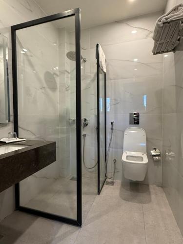 a bathroom with a toilet and a glass shower at S Chalet Islamabad in Islamabad