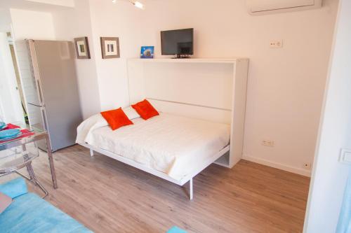 1 dormitorio con 1 cama con 2 almohadas de color naranja en Agata 501, en Benalmádena