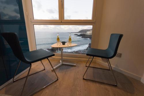 two chairs and a table in front of a window at Virginia's Dream Panoramic Sea View Loft in Las Palmas de Gran Canaria