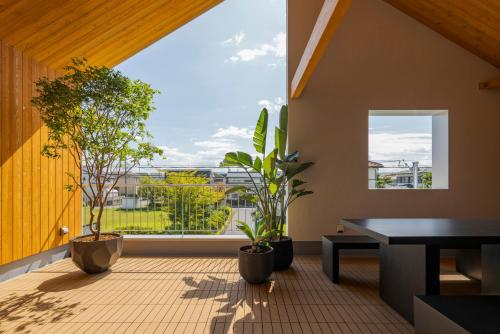 a room with plants and a large window at NAGASHIMA clas in Kuwana