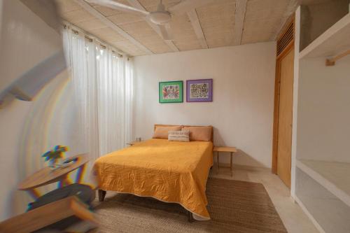 a bedroom with a bed and a table in it at Las Guayas, depto Ceh in Progreso