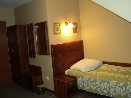 a small bedroom with a bed and a staircase at Hotel Primagor in Szydłowiec