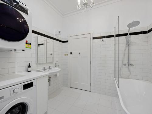 a white bathroom with a sink and a washing machine at The Gables in Marysville