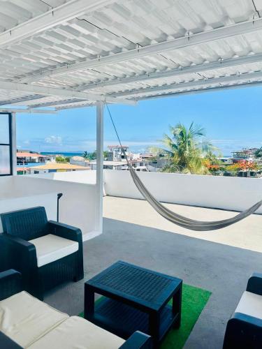 a patio with a hammock and a view of the ocean at Suite Economy in Puerto Ayora