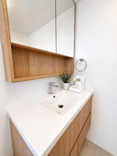 a bathroom with a sink and a mirror at Stylish 1 Bedroom with Private Rooftop Spa at the Aegean in Mooloolaba
