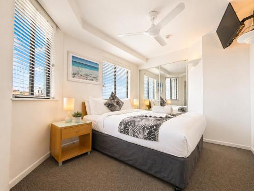 a bedroom with a large bed and a flat screen tv at Stylish 1 Bedroom with Private Rooftop Spa at the Aegean in Mooloolaba
