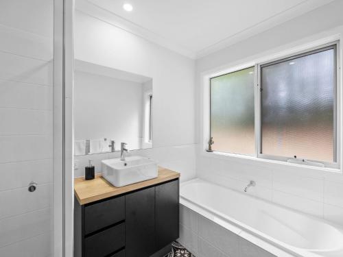 a white bathroom with a sink and a mirror at The Nest on Hull in Marysville