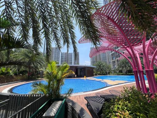 a large swimming pool with palm trees and buildings at MH Home in Long Bình
