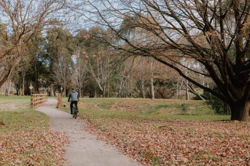 a person riding a bike down a path in a park at Tiny Boorowa by Tiny Away in Boorowa
