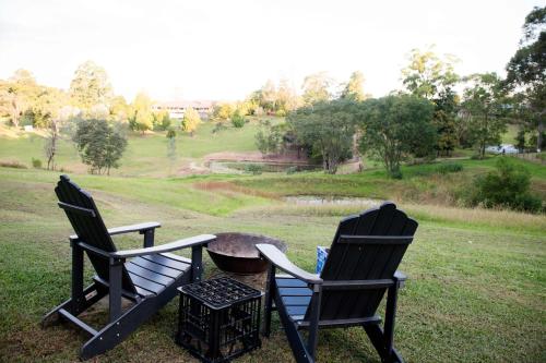 two black chairs and a table in a field at Tiny Inja 2 by Tiny Away in Comleroy