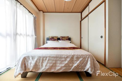 a bed in a room with a large window at ESPERANZA103 広い綺麗快適高速WiFi in Tokyo