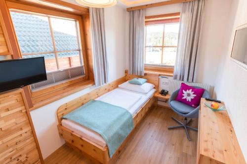 a bedroom with a bed and a desk and a chair at Haus Christophorus in Mariapfarr