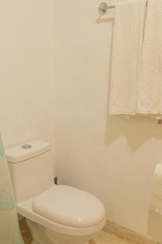 a bathroom with a white toilet and a towel at Las Guayas, depto Ceh in Progreso