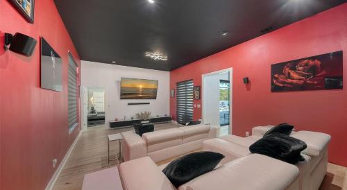 a living room with red walls and white furniture at Stay & Play Sarasota in Sarasota