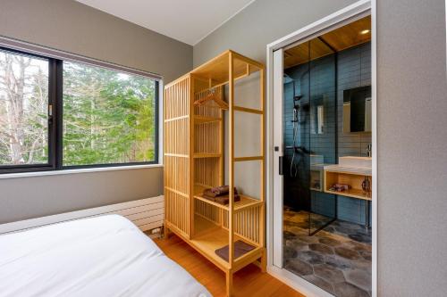 a bedroom with a shower and a bed and a window at COCO VILLA ニセコアンヌプリ-Niseko Annupuri in Rankoshi