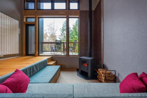 a living room with a blue couch and a fireplace at COCO VILLA ニセコアンヌプリ-Niseko Annupuri in Rankoshi