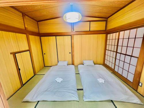 a room with two beds in the middle of it at 古民家松 in Isumi