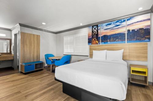 a hotel room with a bed and a desk at Days Inn by Wyndham San Francisco S/Oyster Point Airport in South San Francisco