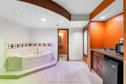 a large bathroom with a tub and a sink at Days Inn by Wyndham Minot in Minot