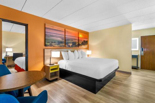 a hotel room with a bed and a table at Days Inn by Wyndham Minot in Minot