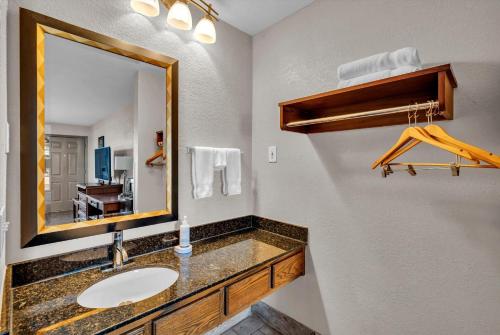 a bathroom with a sink and a mirror at Baymont by Wyndham Warner Robins in Warner Robins