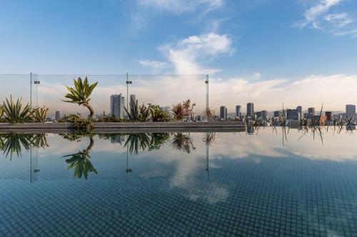 a swimming pool with a city skyline in the background at Andaz Condesa Mexico City, By Hyatt in Mexico City