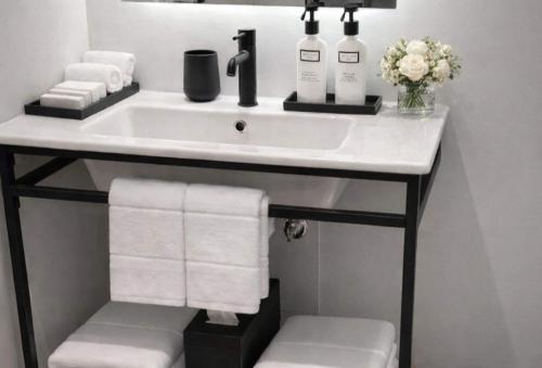 a bathroom sink with towels and wine bottles on it at Dolce by Wyndham Miami Beach in Miami Beach