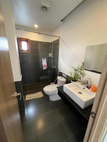 a bathroom with a sink and a toilet and a mirror at Vindy House in Da Lat