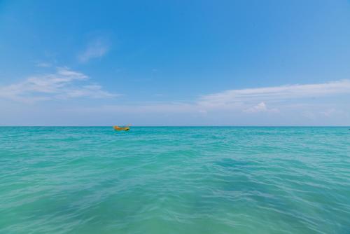 a boat in the middle of the ocean at Munjoh Ocean Resort - Private Beachfront Luxury Retreat in Havelock in Havelock Island